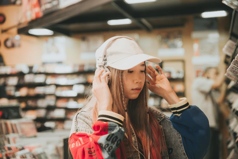 a woman standing in a store talking on a cell phone, an album cover, trending on pexels, hyperrealism, wearing a baseball cap, young asian girl, girl with plaits, girl wearing headphones