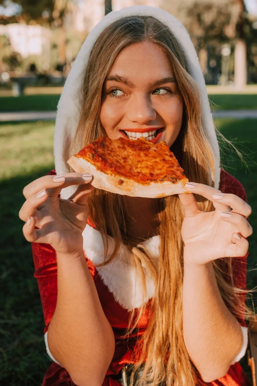 a woman in a santa outfit eating a slice of pizza, a photo, by Julia Pishtar, pexels contest winner, renaissance, at a park, sydney sweeney, headshot profile picture, 15081959 21121991 01012000 4k