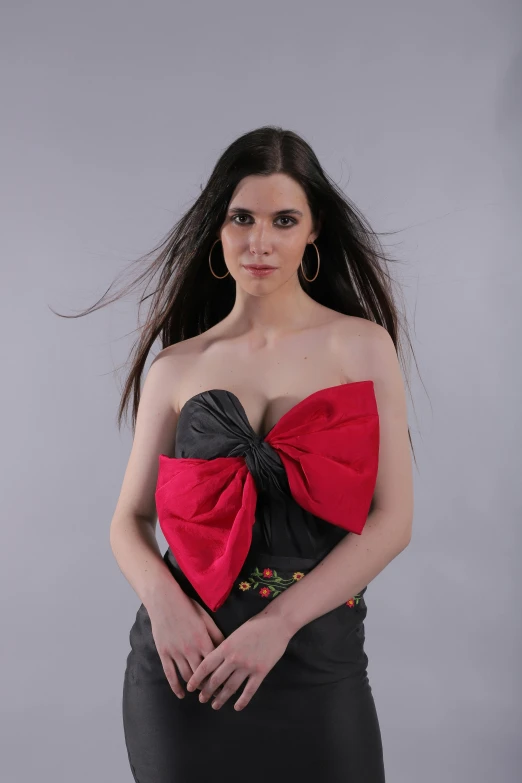 a woman in a black dress with a red bow, an album cover, inspired by Carlo Mense, reddit, tifa lockhart portrait, pose 4 of 1 6, chest up bust shot, marvelous designer