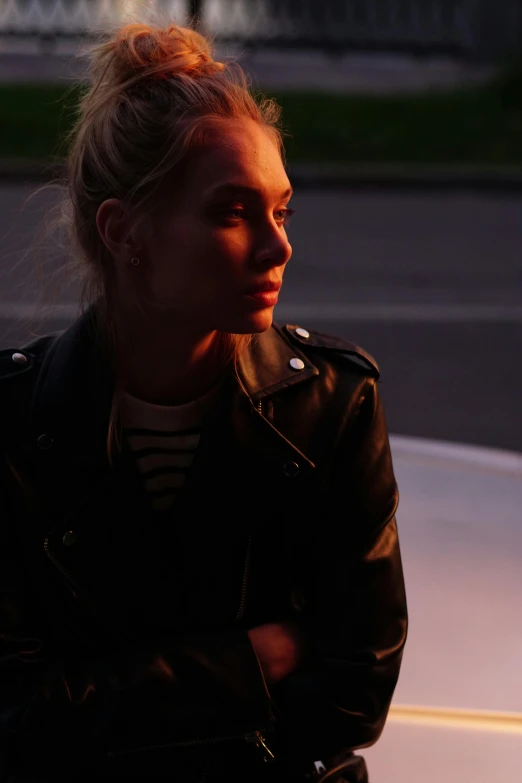 a woman sitting on the hood of a white car, inspired by Nan Goldin, unsplash, wearing leather jacket, portrait of margot robbie, evening lighting, promotional image