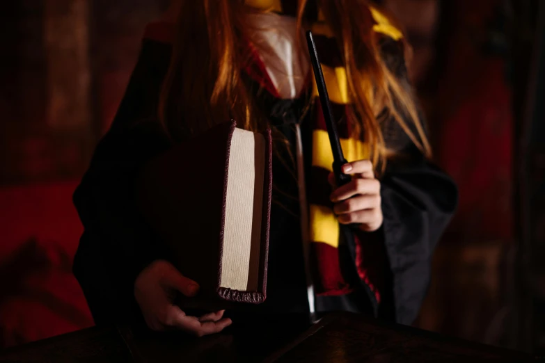 a woman in a harry potter costume holding a book, trending on pexels, process art, hogwarts gryffindor common room, middle close up composition, 1 4 9 3, student