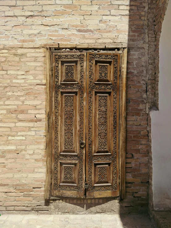 a wooden door sitting on the side of a brick building, samarkand, 8 k intricate detail, worn, brown