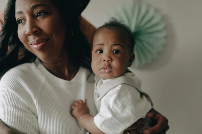 a woman holding a baby in her arms, a portrait, by Arabella Rankin, pexels contest winner, diverse, thumbnail, bowater charlie and brom gerald, high quality image