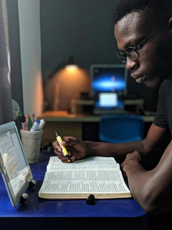 a man sitting at a desk in front of a laptop, by Carey Morris, academic art, bible, david uzochukwu, thumbnail, shot on iphone