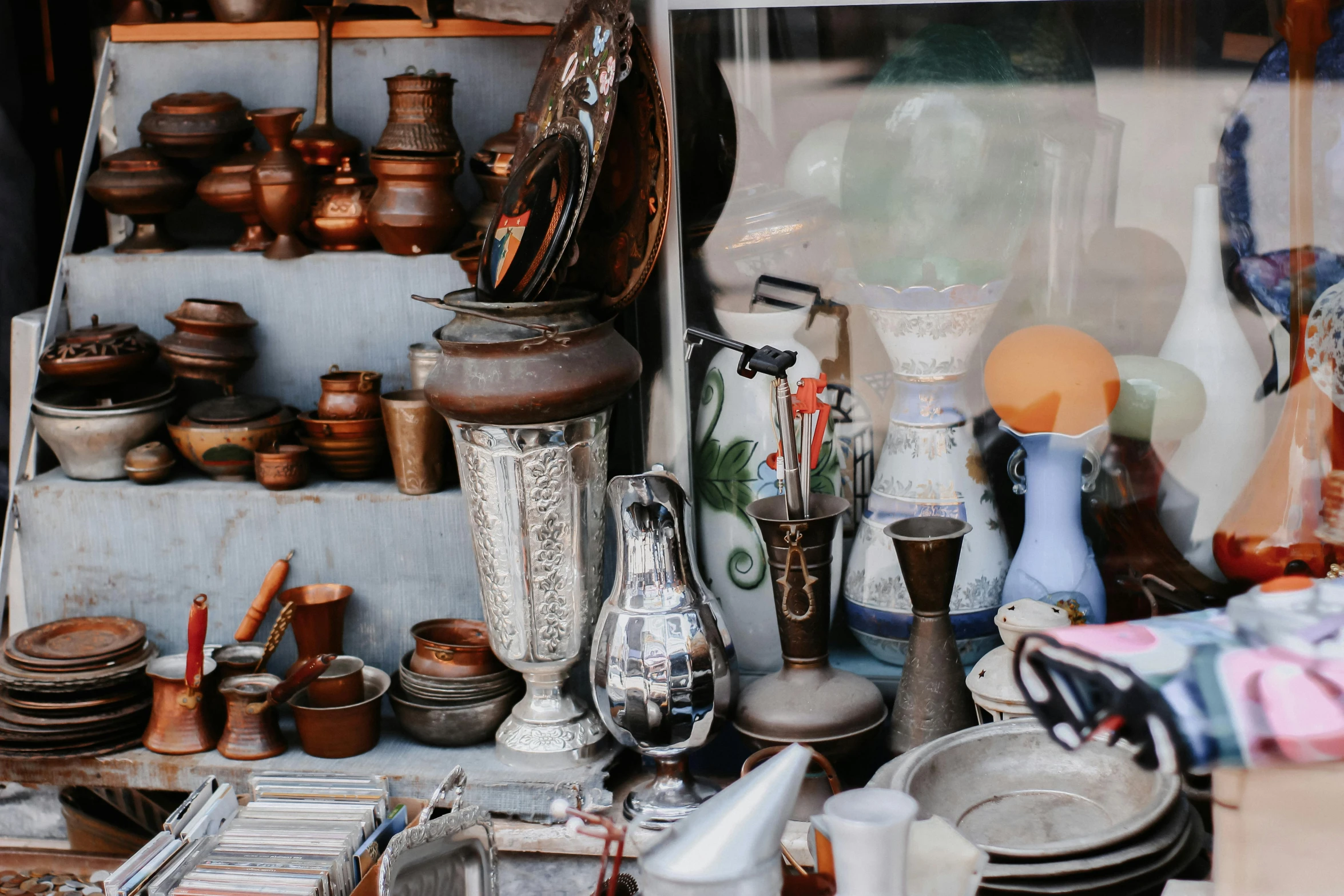 a bunch of pots and pans that are on a table, trending on unsplash, cloisonnism, street vendors, overturned ornate chalice, mirror and glass surfaces, seen from outside