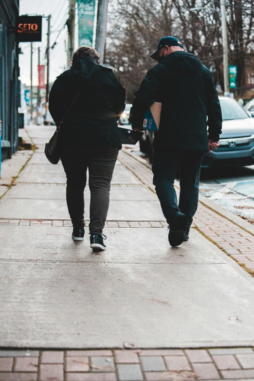 a couple of people walking down a sidewalk, trending on pexels, an overweight, lesbian, february), highcontrast