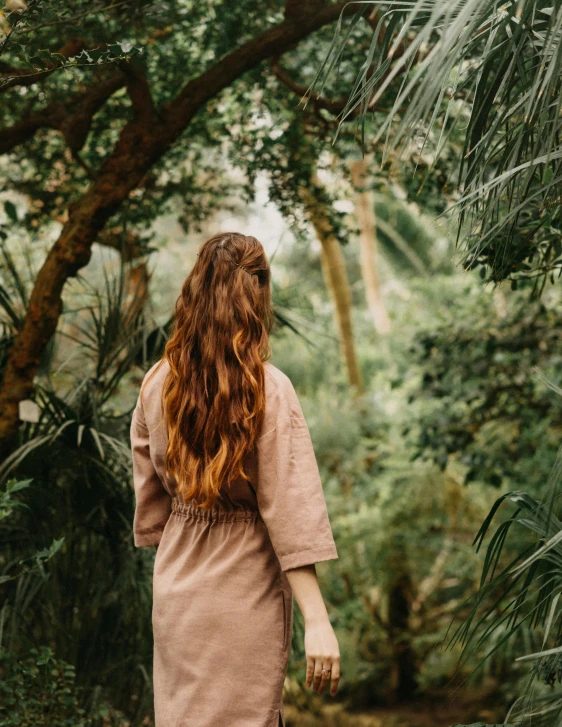 a woman standing in the middle of a forest, trending on unsplash, renaissance, brown wavy hair, tropics, low quality photo, multiple stories