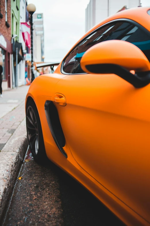 an orange sports car parked on the side of a street, pexels contest winner, photorealism, closeup 4k, instagram post, low detailed, orange and black