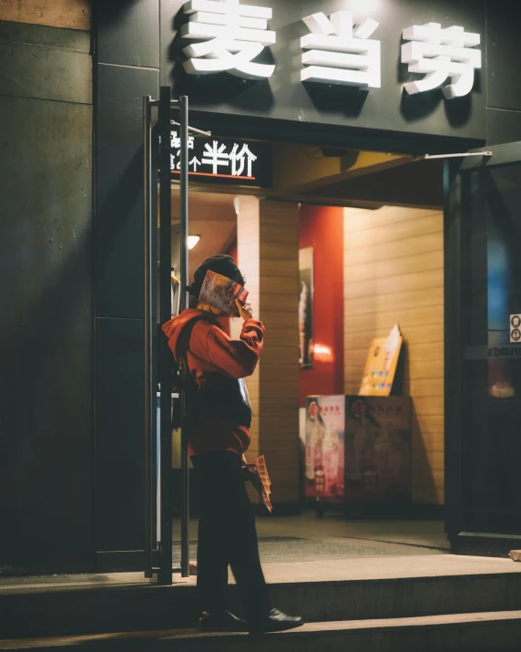 a person standing outside of a building at night, trending on unsplash, ukiyo-e, restaurant, low quality photo, cell phone photo, ethnicity : japanese