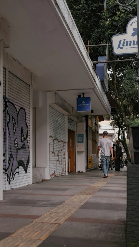 a man riding a skateboard down a sidewalk, by Alejandro Obregón, unsplash, graffiti, shuttered mall store, sao paulo in the year 2 0 7 0, people walking down a street, greece