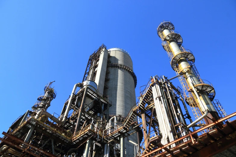 a large industrial plant with a blue sky in the background, a picture, unsplash, renaissance, tubes and gauges, 2 5 6 x 2 5 6 pixels, towering, from waist up