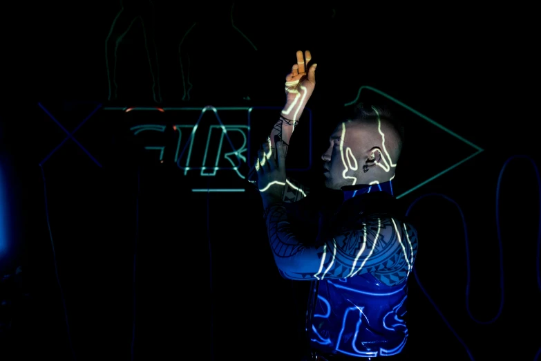 a man standing in front of a neon sign, by Dan Frazier, cybernetic fire armor, light emitting from fingertips, reach, tron