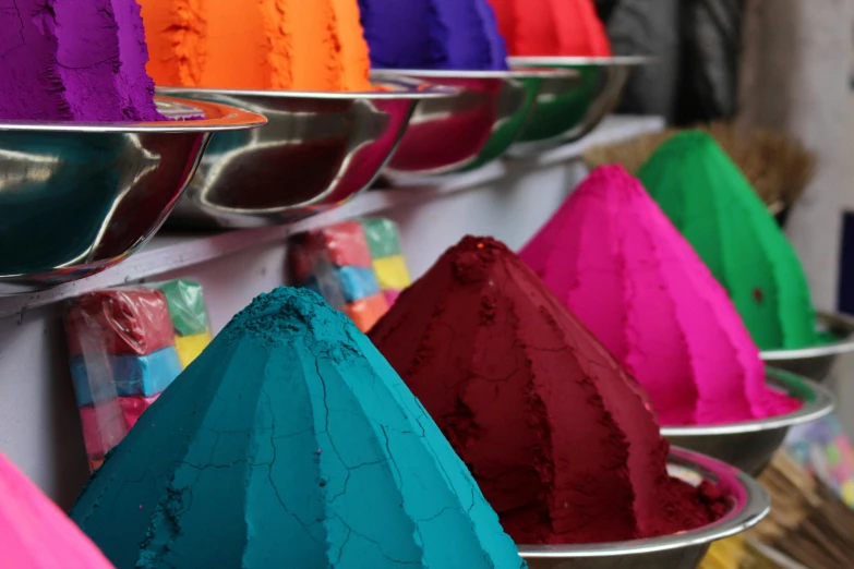 a number of bowls of colored powder on a shelf, a silk screen, inspired by Steve McCurry, trending on unsplash, thumbnail, market stalls, magenta colours, rainbow coloured rockets