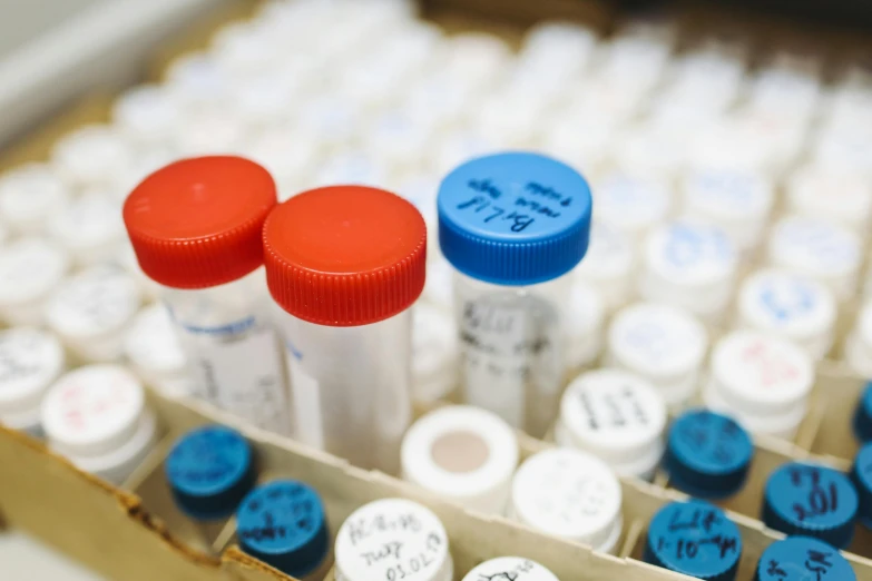 a box filled with lots of white and blue vials, stood in a lab, labels, tubes and gauges, uhq