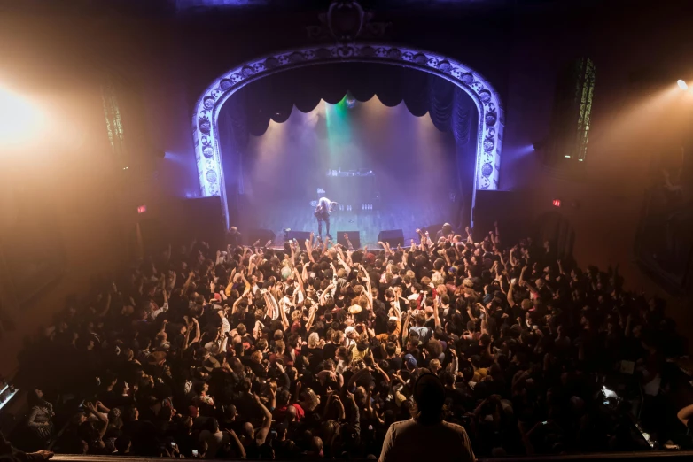 a man standing on top of a stage in front of a crowd, by Sam Black, nightlife, inside a grand, wiz khalifa, sanctuary