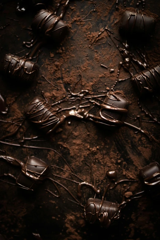 a close up of a bunch of forks and spoons, an album cover, by Andries Stock, trending on pexels, smothered in melted chocolate, inside of a dark cave, dark runes, chocolate. rugged