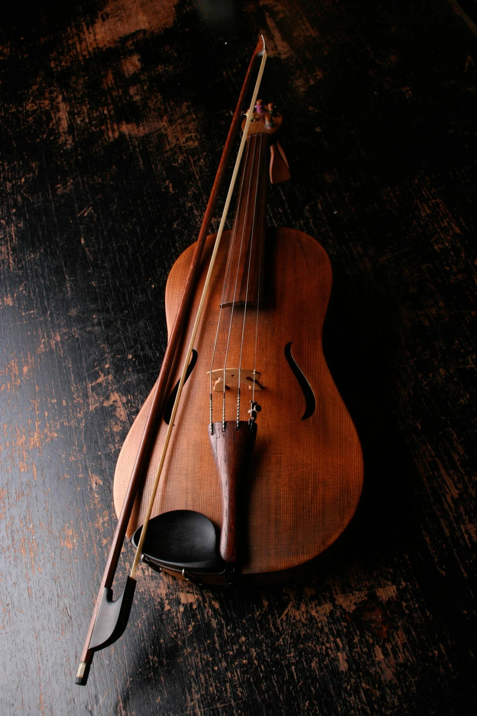 a violin sitting on top of a wooden table, standing on top of a violin