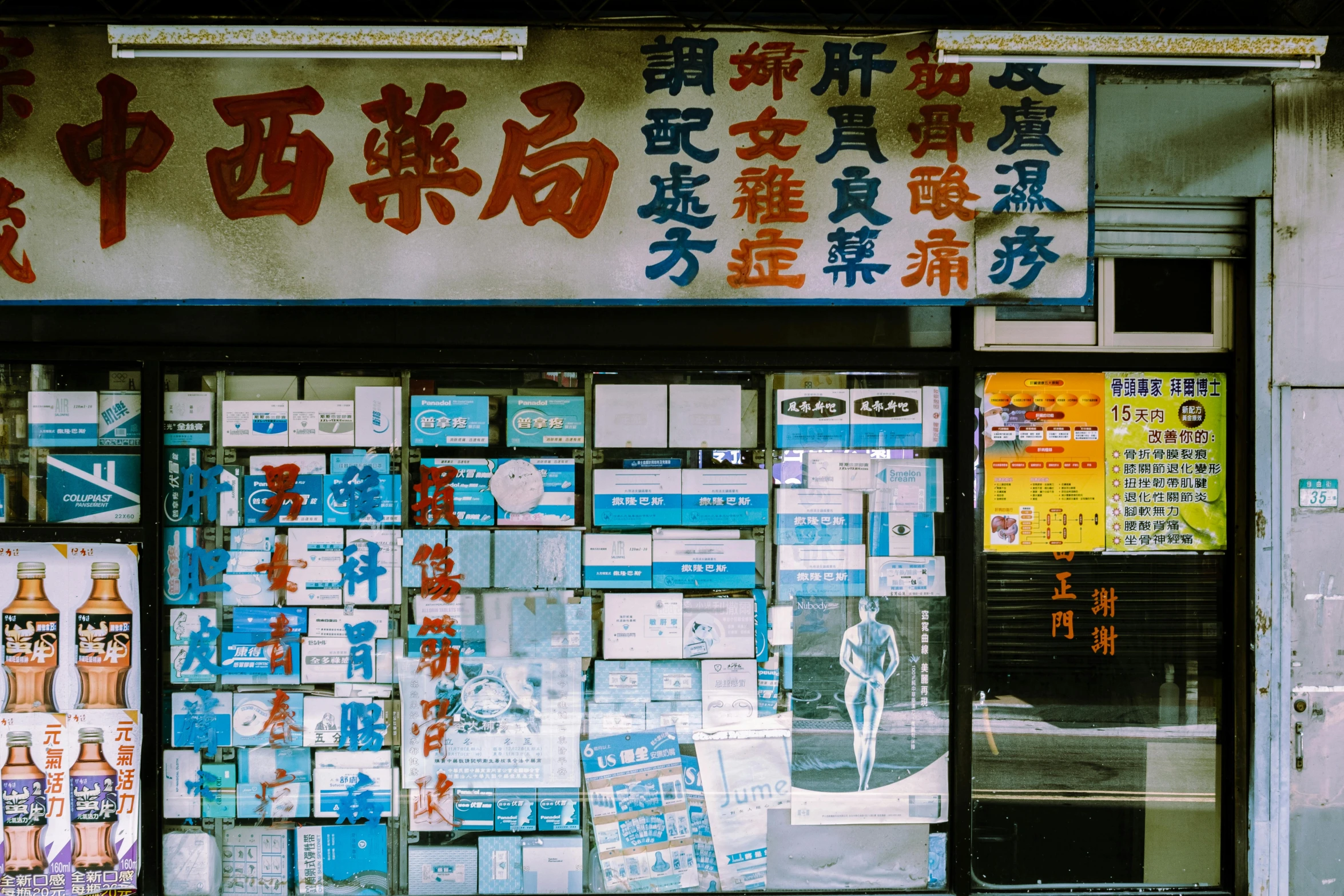 a man sitting on a bench in front of a store, a silk screen, unsplash, kowloon walled city style, pharmacy, 🚿🗝📝, lots of signs and shops