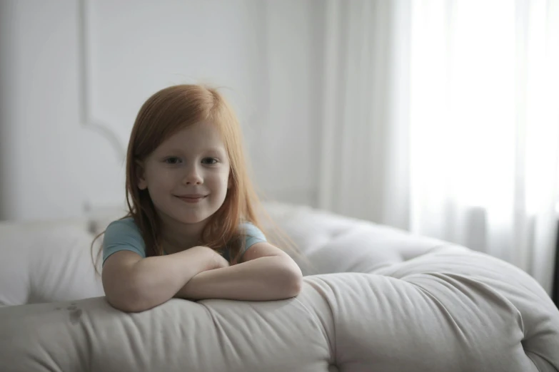 a little girl sitting on top of a white couch, soft lighting 8 k resolution, ginger hair with freckles, advert, taken with sony alpha 9