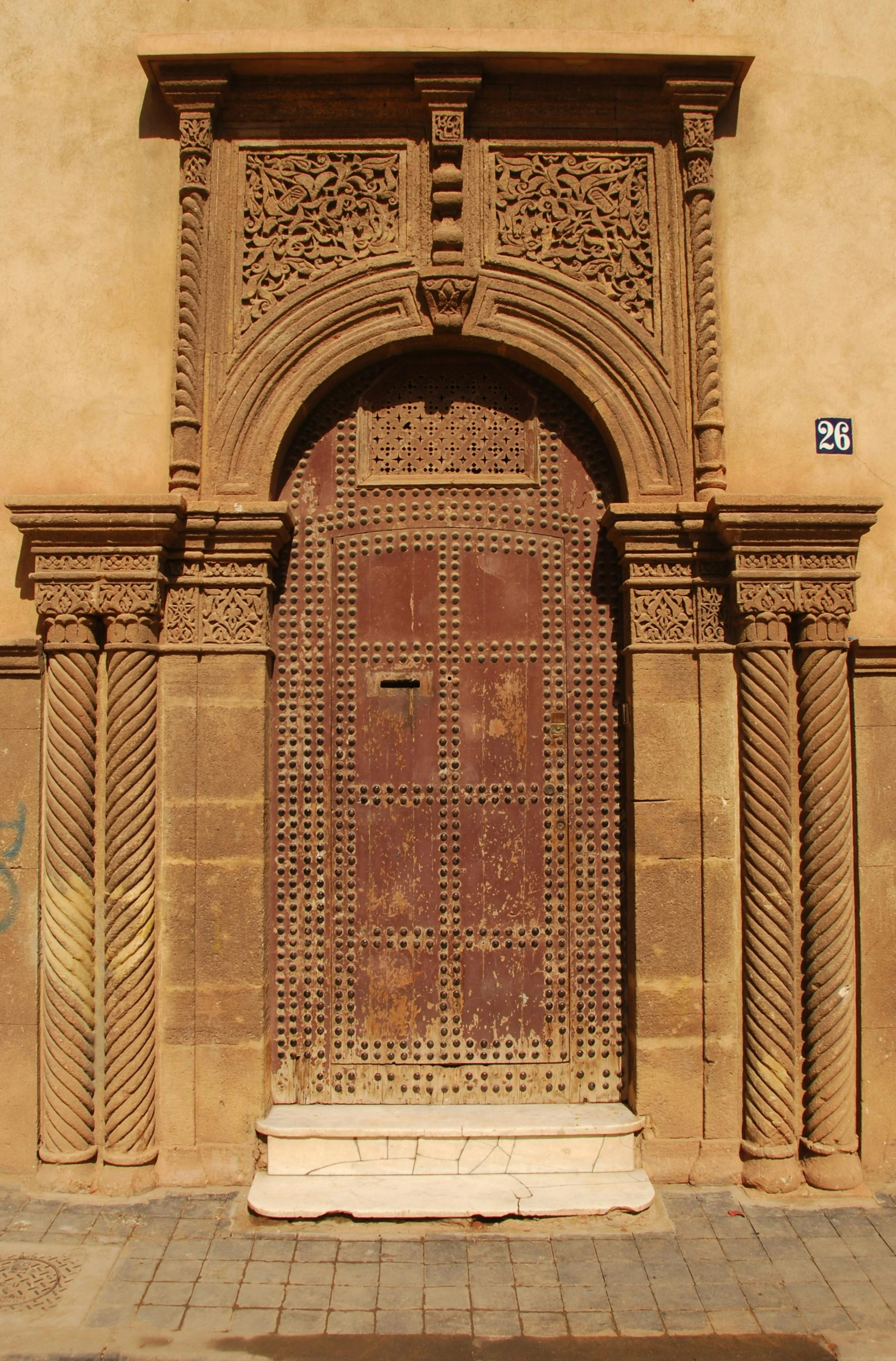 a brown door sitting on the side of a building, inspired by Albert Dorne, middle eastern details, monserrat gudiol, well preserved, ochre