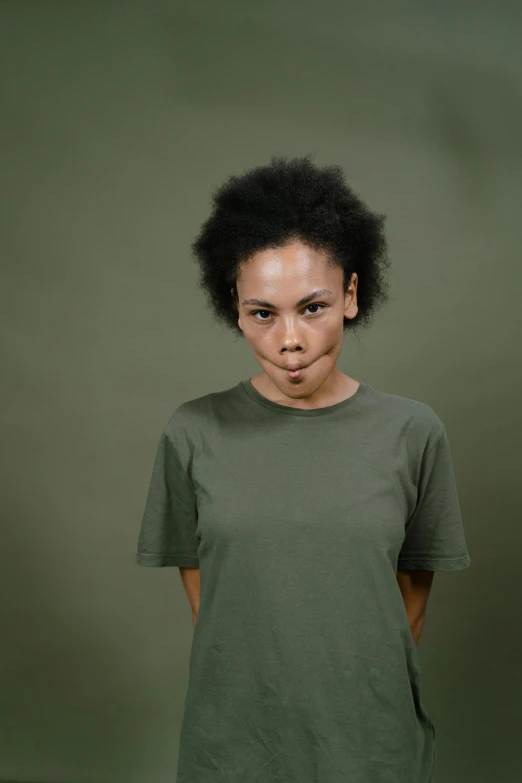 a woman in a green shirt posing for a picture, by Andries Stock, minimalism, mixed-race woman, annoyed, high resolution photo, light skin