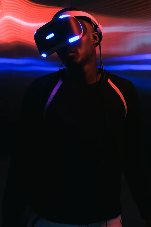 a man standing in front of a red and blue light, pexels, afrofuturism, wearing a vr-headset, ( ( dark skin ) ), eyeless, full body close-up shot