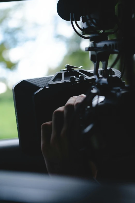 a person holding a camera in a car, production photo, close-up shot taken from behind, natural lighting. 8 k, hasselblad quality