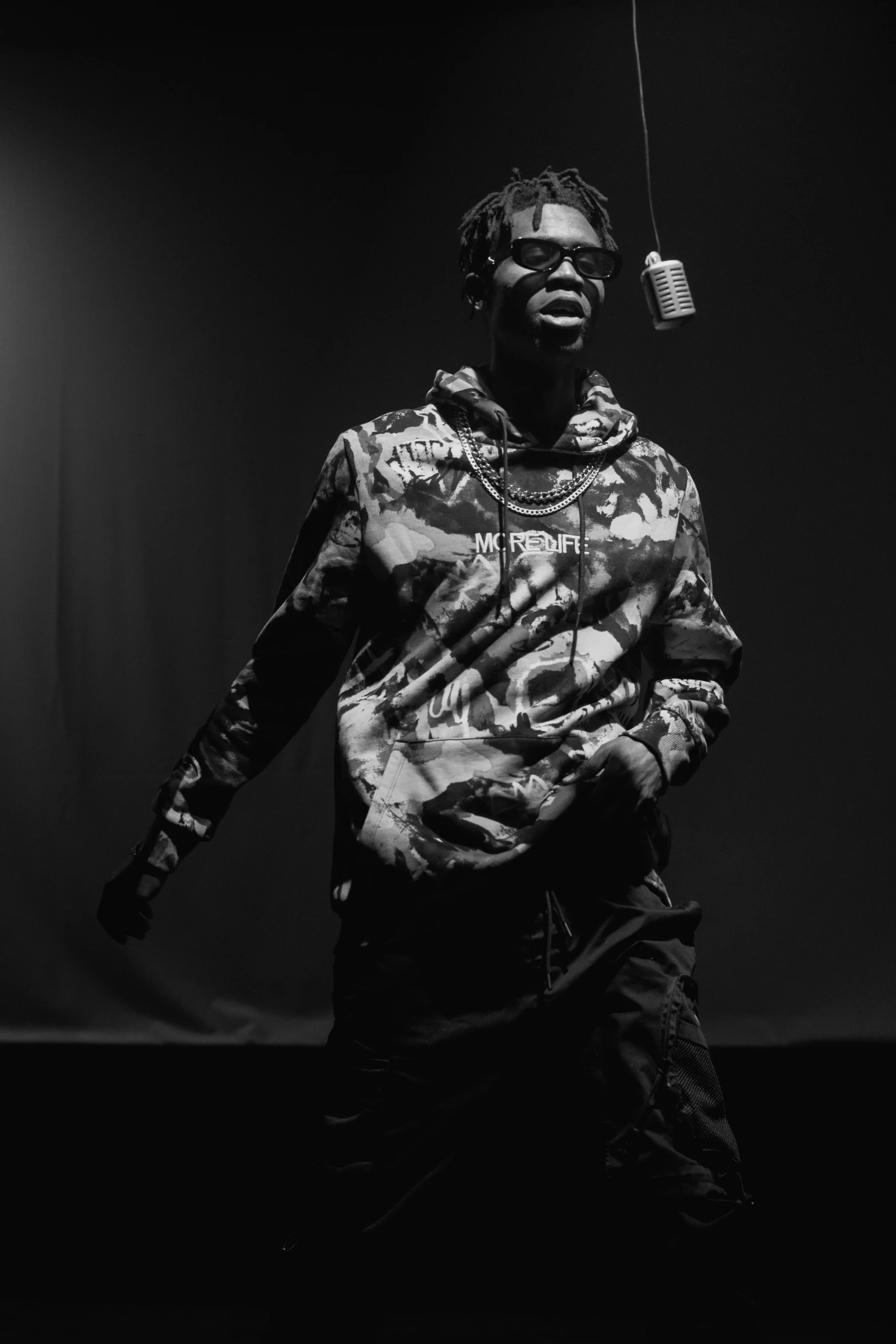 a man standing in front of a microphone, an album cover, unsplash, visual art, young thug, dark monochrome, full body picture, ( ( theatrical ) )