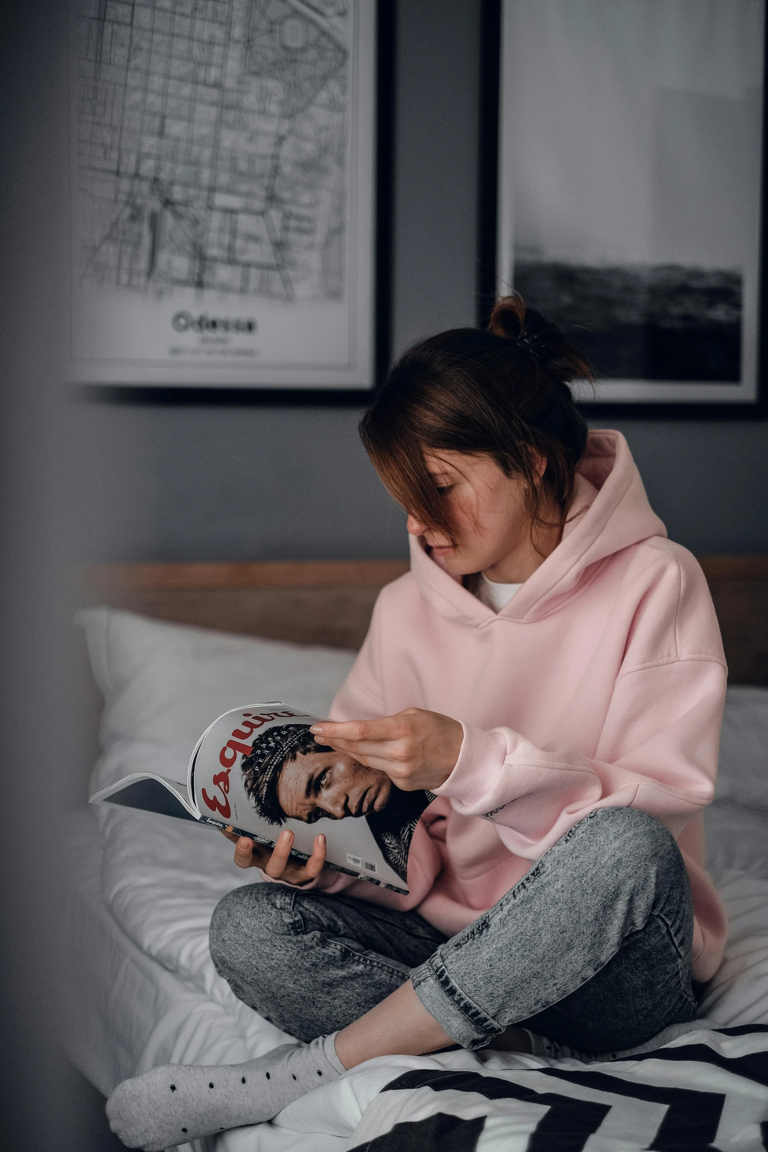 a woman sitting on a bed reading a magazine, a picture, by Adam Marczyński, trending on pexels, hyperrealism, wearing a pink hoodie, avatar image, portrait of depressed teen, holding a drink