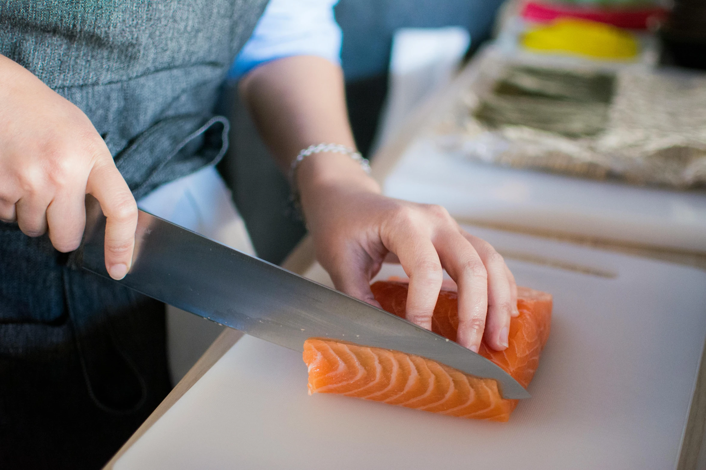 a person cutting up a piece of salmon on a cutting board, inspired by Maki Haku, pexels contest winner, amanda lilleston, holding a kitchen knife, no - text no - logo, lachlan bailey