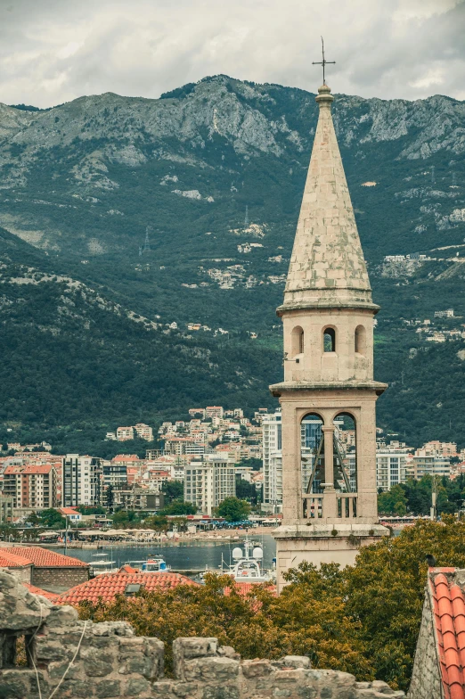 a clock tower towering over a city with mountains in the background, inspired by Ivan Lacković Croata, baroque, coastline, tall stone spires, top - down photograph