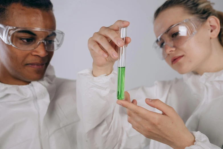 a man and a woman in lab coats holding test tubes, trending on pexels, beautiful green liquid, avatar image, college girls, spanish