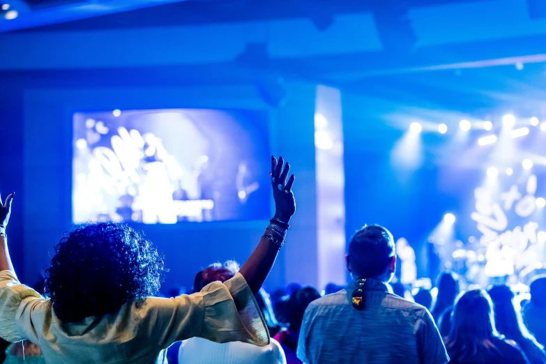 a group of people standing in front of a stage, pexels, happening, vibrant blue, scene from church, thumbnail