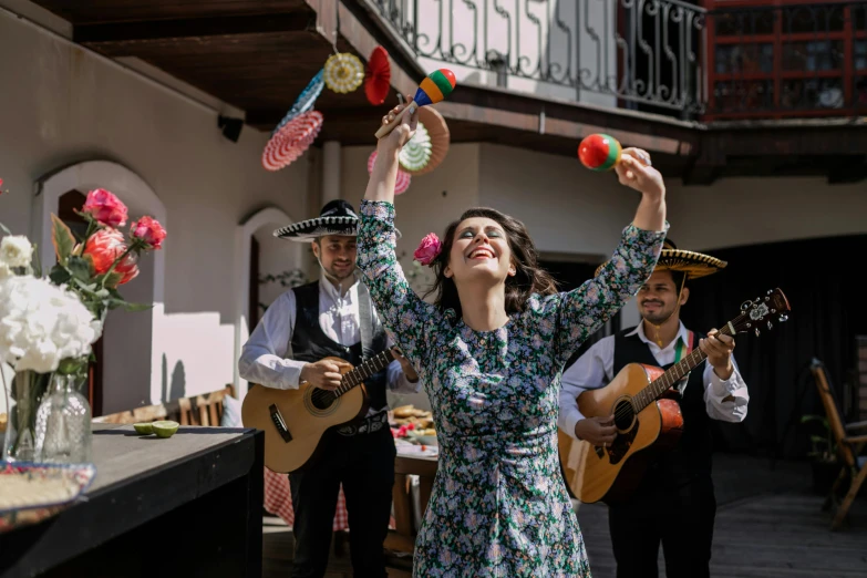 a group of people standing on top of a wooden floor, an album cover, by Julia Pishtar, pexels contest winner, arabesque, folklorico, throwing spaghetti and meatballs, carmen sings beautifully, at the terrace