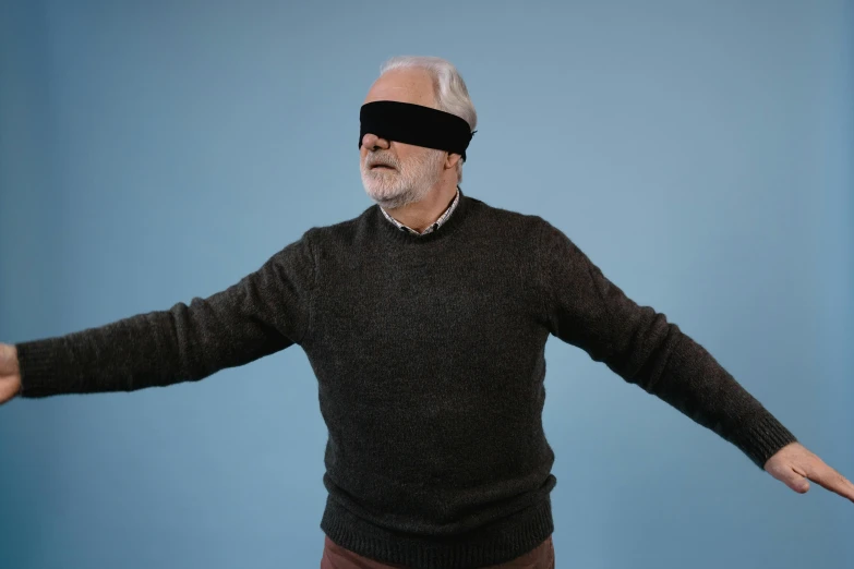 a man with a blindfold on his face, by Jesper Knudsen, pexels contest winner, magical realism, wearing a sweater, shrugging arms, middle - age, floating vr headsets