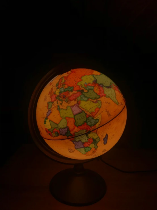 an illuminated globe sitting on top of a table, by IAN SPRIGGS, beige, multicoloured, glow in the dark, orange