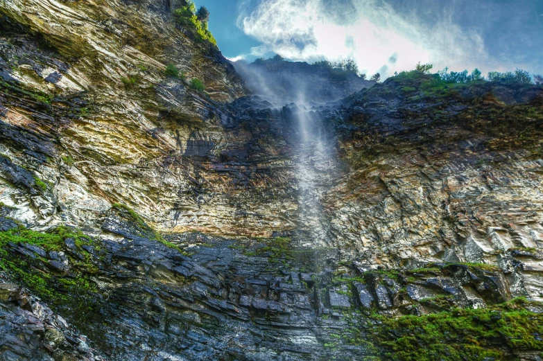 a waterfall flowing down the side of a cliff, by Muggur, pexels contest winner, romanticism, hdr!, in the swiss alps, view from below, dramatic lighting - n 9