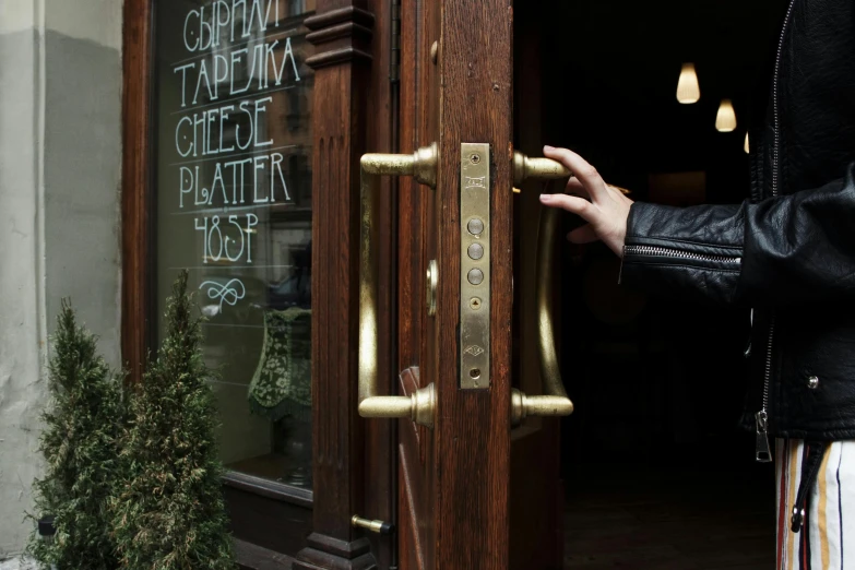 a close up of a person opening a door, by Emma Andijewska, private press, restaurant, brass plated, vladimir pchelin, shop front