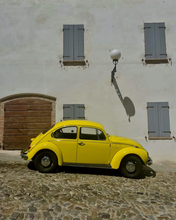 a yellow car parked in front of a building, a photo, pexels contest winner, french village exterior, beetle, bright white, square