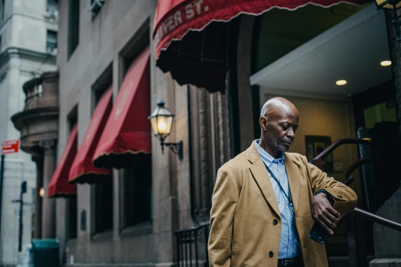 a man that is standing in front of a building, by Andrew Stevovich, pexels contest winner, gus fring, classic gem, people outside walk, promotional image