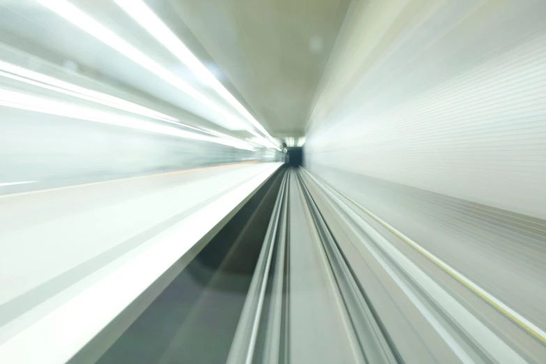 a blurry image of a train going through a tunnel, inspired by Ryoji Ikeda, unsplash, light and space, aluminium, white, narrow, hdri