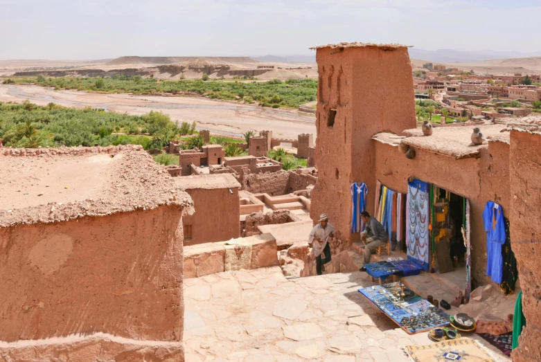 a view of a village from the top of a hill, pexels contest winner, les nabis, standing next to desert oasis, terracotta, shops, moorish architecture