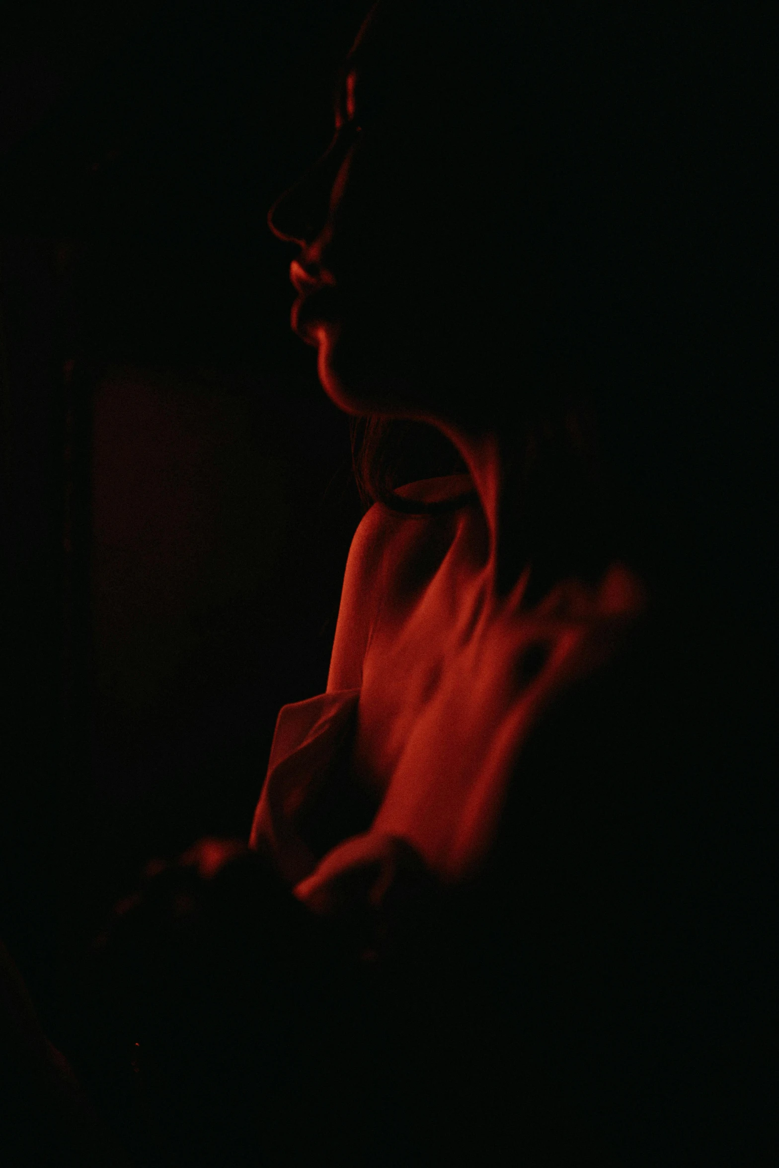 a woman smoking a cigarette in the dark, inspired by Elsa Bleda, unsplash, figurative art, red monochrome, exposed torso, silhouette :7, silhouette of man