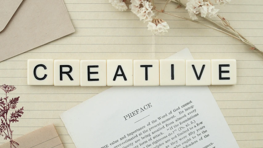 a piece of paper with the word creative written on it, inspired by artist, trending on pexels, interactive art, letters, modelling, cream paper, board games on a table