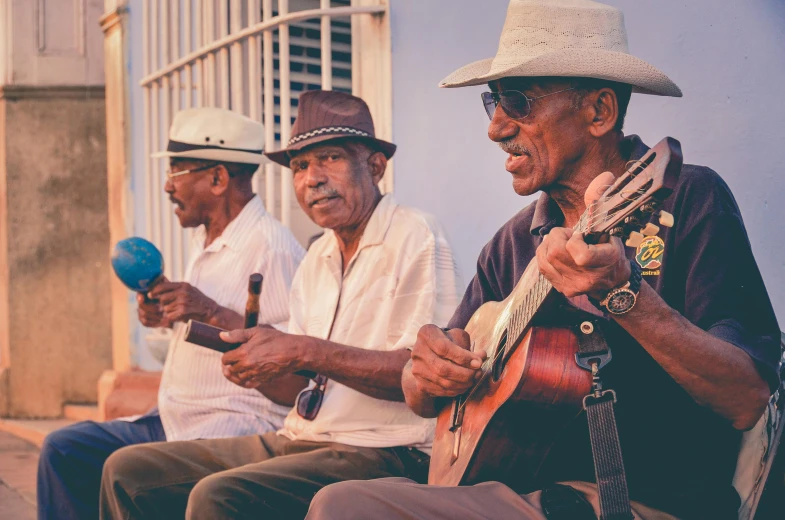 a group of men sitting next to each other playing instruments, pexels contest winner, cuban setting, wearing sunglasses and a cap, avatar image, two old people