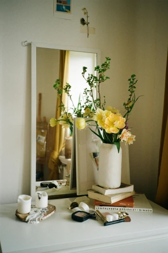 a white dresser topped with a vase filled with flowers, shot on kodak ektar, mirror, yellow, dwell