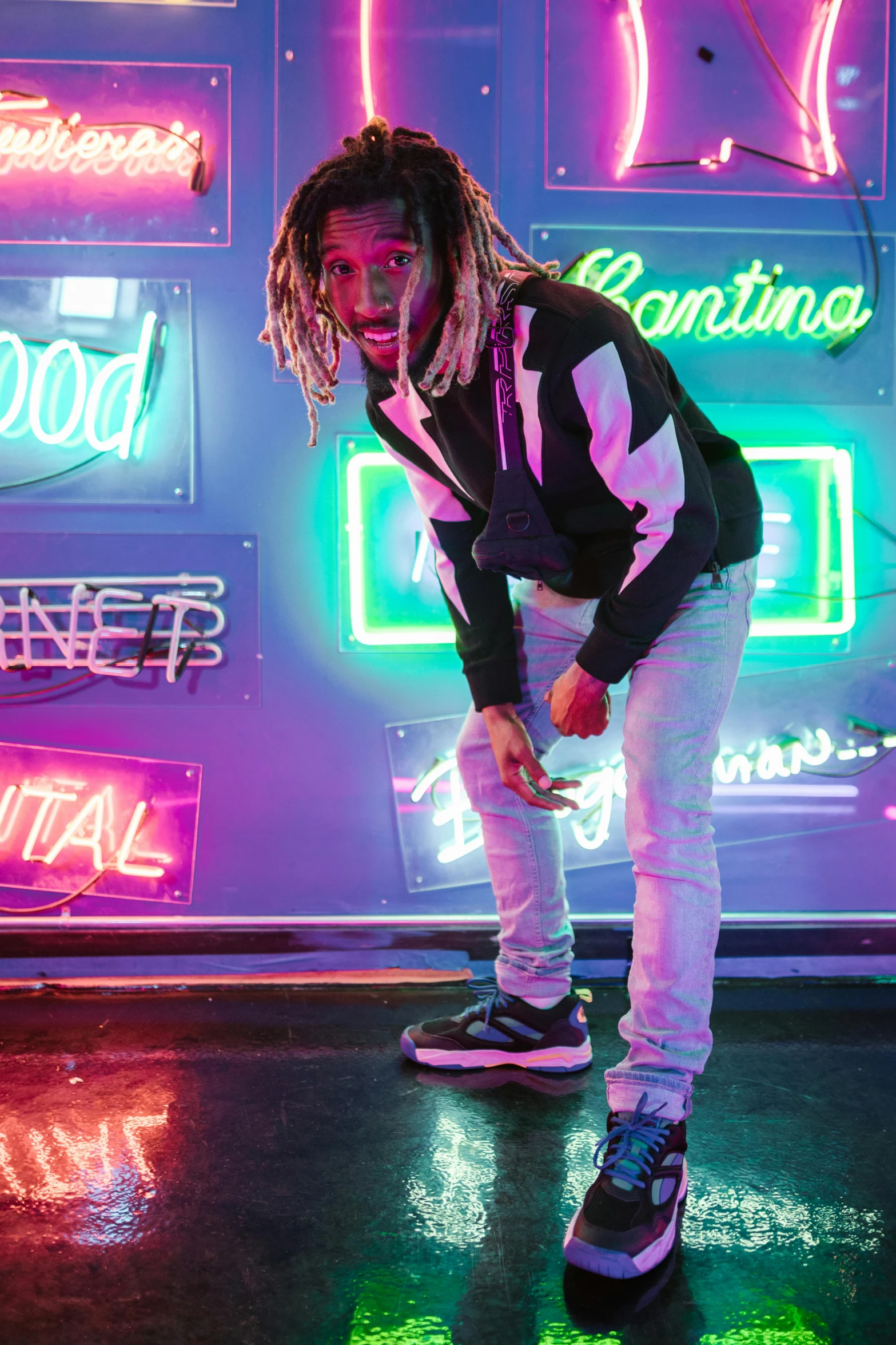 a man standing on a skateboard in front of neon signs, an album cover, trending on pexels, dreads, yzy gap, good lighted photo, posed