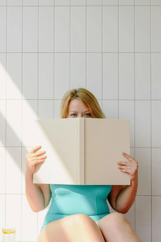 a woman sitting on a toilet reading a book, an album cover, by Carey Morris, unsplash, pareidolia, blond, big open book, rectangle
