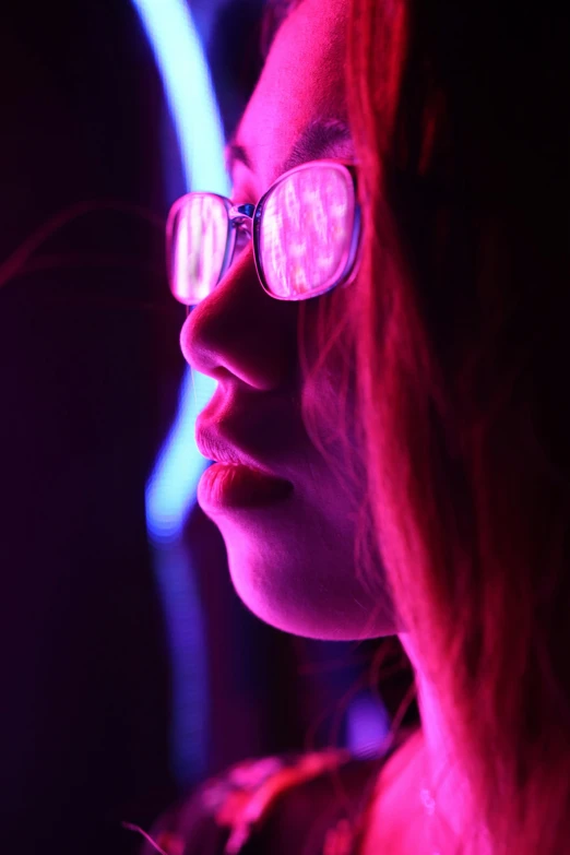 a close up of a person wearing glasses, by David Donaldson, pexels contest winner, light and space, fuschia leds, a woman's profile, cool lights, smooth bioluminescent skin