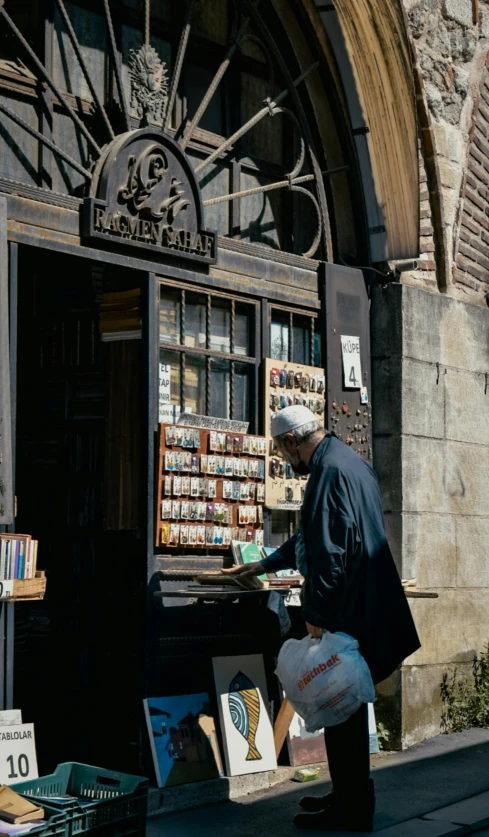 a man standing in front of a book store, by Jan Tengnagel, pexels, private press, having a snack, delivering mail, robed, thumbnail